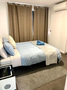 ein Schlafzimmer mit einem Bett und einem blauen Handtuch darauf in der Unterkunft Comfy & Sunny home in Wellington in Wellington