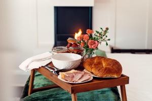 una mesa con una barra de pan y un plato de comida en Rosemont House Luxury BnB, en Noojee