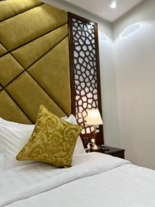 a bed with a yellow pillow on top of it at شقق جيهان الخاصة in Medina