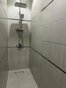 a bathroom with a shower with white tile at شقق جيهان الخاصة in Al Madinah