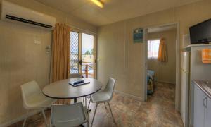 a small room with a table and chairs and a refrigerator at Governors Hill Carapark in Goulburn