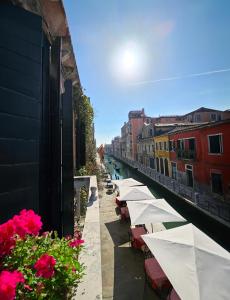 una fila de mesas y sombrillas en una calle de la ciudad en Messner Palace en Venecia