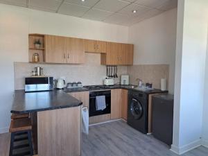 a kitchen with a stove and a washer and dryer at The Muscadel - Paarl - Self Catering Apartment in Paarl