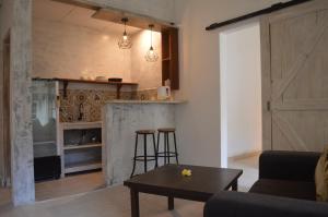 a living room with a table and a kitchen at Little Pond Homestay in Sanur