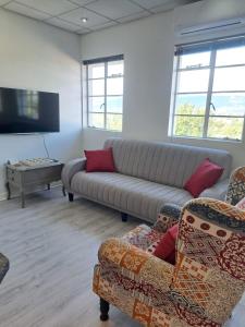 a living room with a couch and two chairs at The Muscadel - Paarl - Self Catering Apartment in Paarl