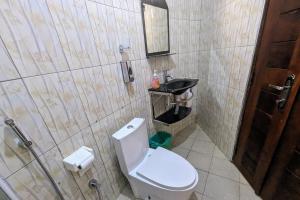a bathroom with a toilet and a sink at Oslo Gardens Bed & Breakfast in Entebbe