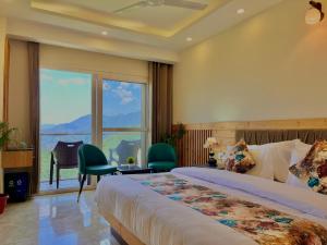Habitación de hotel con cama y ventana grande en The Pine Woods - A Four Star Luxury Resort in Mussoorie, en Mussoorie