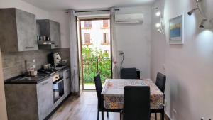 a kitchen with a table with chairs and a table and a window at Loft le Due Effe al Capo in Palermo