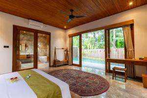 - une chambre avec un lit, un bureau et une fenêtre dans l'établissement Villa Rabita, à Ubud