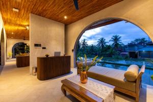 - un salon avec un lit et une piscine dans l'établissement Villa Rabita, à Ubud