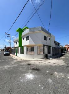 um edifício branco e verde ao lado de uma rua em Lagrande Home em La Grúa