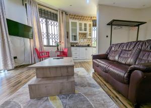 a living room with a couch and a table at Oslo Gardens Bed & Breakfast in Entebbe +29 photos