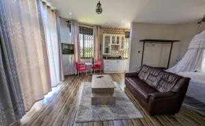 ein Wohnzimmer mit einem Sofa und einem Tisch in der Unterkunft Oslo Gardens Bed & Breakfast in Entebbe