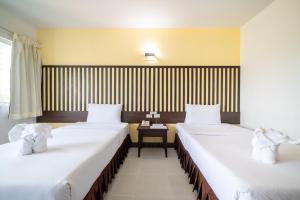 2 camas en una habitación de hotel con mesa en J A Plus Hotel en Pattaya Central