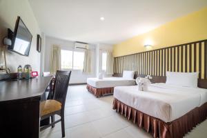 ein Hotelzimmer mit 2 Betten und einem Schreibtisch in der Unterkunft J A Plus Hotel in Pattaya