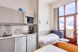 una pequeña cocina con mesa y ventana en Résidence Antarès - maeva Home - Appartement 2 pièces 4 personnes - Prest 214, en Avoriaz