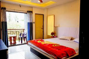 a bedroom with a large bed and a balcony at HOTEL SAMRUDDHI in Panchgani