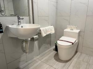 AWA Hotel في روتوروا: حمام أبيض مع حوض ومرحاض