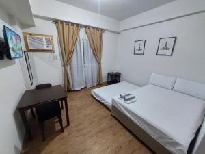 a small bedroom with a bed and a desk at ANIA ROOMS@AMANI GRAND RESIDENCES NEAR AIRPORT in Mactan