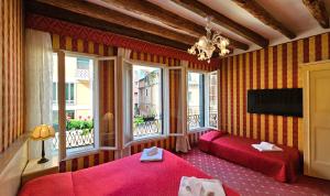 ヴェネツィアにあるCa' Messner 5 Leoniのベッドルーム1室(赤いベッド2台、窓付)