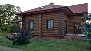 ein Blockhaus mit einer Veranda und einem Hof in der Unterkunft Dom z bali - całoroczny in Poddębice