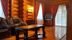 ein Wohnzimmer mit einem Tisch und Stühlen sowie einem TV in der Unterkunft Dom z bali - całoroczny in Poddębice