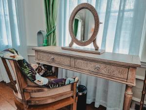 a dressing table with a mirror and a chair at The Swan Hotel in Staines