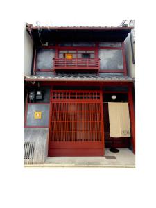 a red door on the side of a building at 京都駅そばの一棟貸し京町家 suiten shichijo 萃点七条 in Kyoto