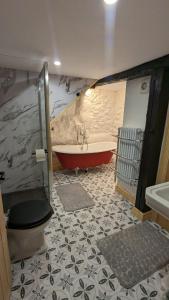 a bathroom with a tub and a toilet and a sink at Grade II Lodge House 2 Bedroom in Trawsfynydd