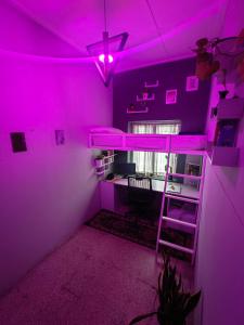 Cette chambre violette comprend des lits superposés et un bureau. dans l'établissement Ward80 Wayanad, à Vythiri