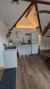 una cocina con armarios blancos y un gran ático en Grade II Lodge House 2 Bedroom en Trawsfynydd