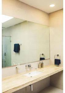 łazienka z umywalką i dużym lustrem w obiekcie Aspire villa 30 w mieście Lonavla