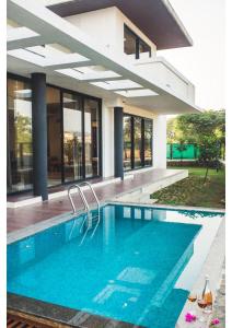 a swimming pool in front of a house at Aspire villa 30 in Lonavala