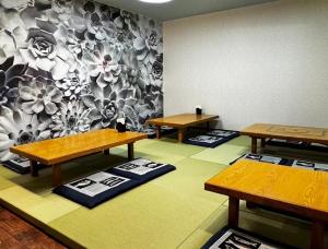 una habitación con 3 mesas y una pared con flores en 三浜館 伊豆大島, en Oshima