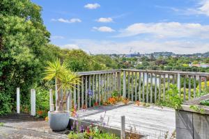 a garden with a wooden fence and a potted plant at Bright Kingsland Contemporary in Auckland