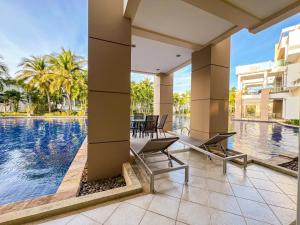 eine Außenterrasse mit Tisch und Stühlen neben einem Pool in der Unterkunft Hua Hin Blue Lagoon-Pool Access in Cha-am