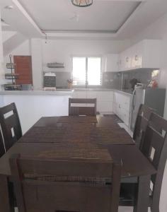 una cocina con mesa de madera y sillas. en Da Arreglados’ Beach House, en Abra de Ilog