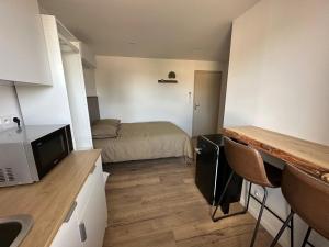 a small room with a bed and a kitchen at Le QG in Codolet