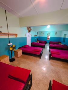 Zimmer mit roten Betten und blauen Wänden in der Unterkunft Ward80 Wayanad in Vythiri