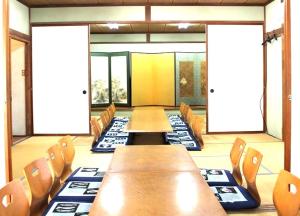 una sala de conferencias con mesas y sillas de madera en 三浜館 伊豆大島, en Oshima