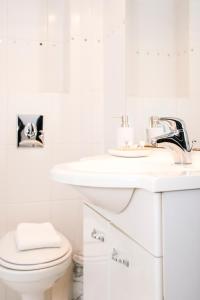 a white bathroom with a sink and a toilet at Studio at Sea in Zandvoort