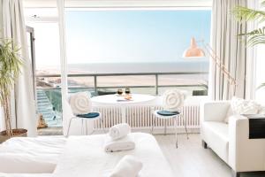 ein Wohnzimmer mit einer weißen Couch und einem Tisch in der Unterkunft Studio at Sea in Zandvoort