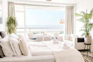 ein Wohnzimmer mit einer weißen Couch mit Kissen in der Unterkunft Studio at Sea in Zandvoort