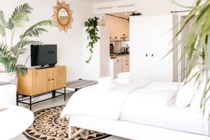 ein weißes Wohnzimmer mit einem weißen Sofa und einem TV in der Unterkunft Studio at Sea in Zandvoort