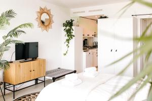 ein Wohnzimmer mit einem TV und einer Küche in der Unterkunft Studio at Sea in Zandvoort