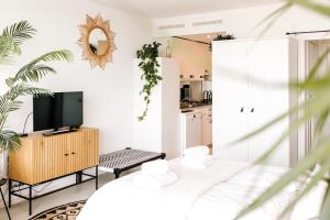 ein Wohnzimmer mit Fernseher und eine Küche in der Unterkunft Studio at Sea in Zandvoort