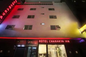 um hotel chandanarma inn à noite com luzes de néon em Airport Hotel Chanakya em Nova Deli