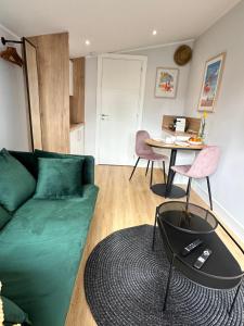 een woonkamer met een groene bank en een tafel bij PHEBUS in Berck-sur-Mer