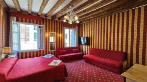 un soggiorno con 2 divani rossi e una TV di Ca' Messner 5 Leoni a Venezia
