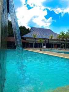 a fountain in the middle of a swimming pool at Cinta Sayang Resort in Sungai Petani